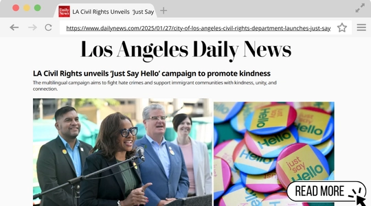 A web browser showing an article from the "Los Angeles Daily News." The headline reads, "LA Civil Rights unveils 'Just Say Hello' campaign to promote kindness." A photo below shows a woman speaking at a podium with several people standing behind her, and an inset of colorful buttons with the words "Hello" and "Just say hello."