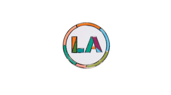 Circular pin with LA in colorful font.