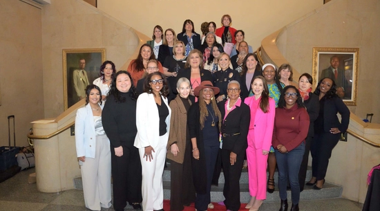 Image of Women of Impact Honorees, Commissioners, and staff lined in on the stairs of the Tom Bradley Room at City Hall.