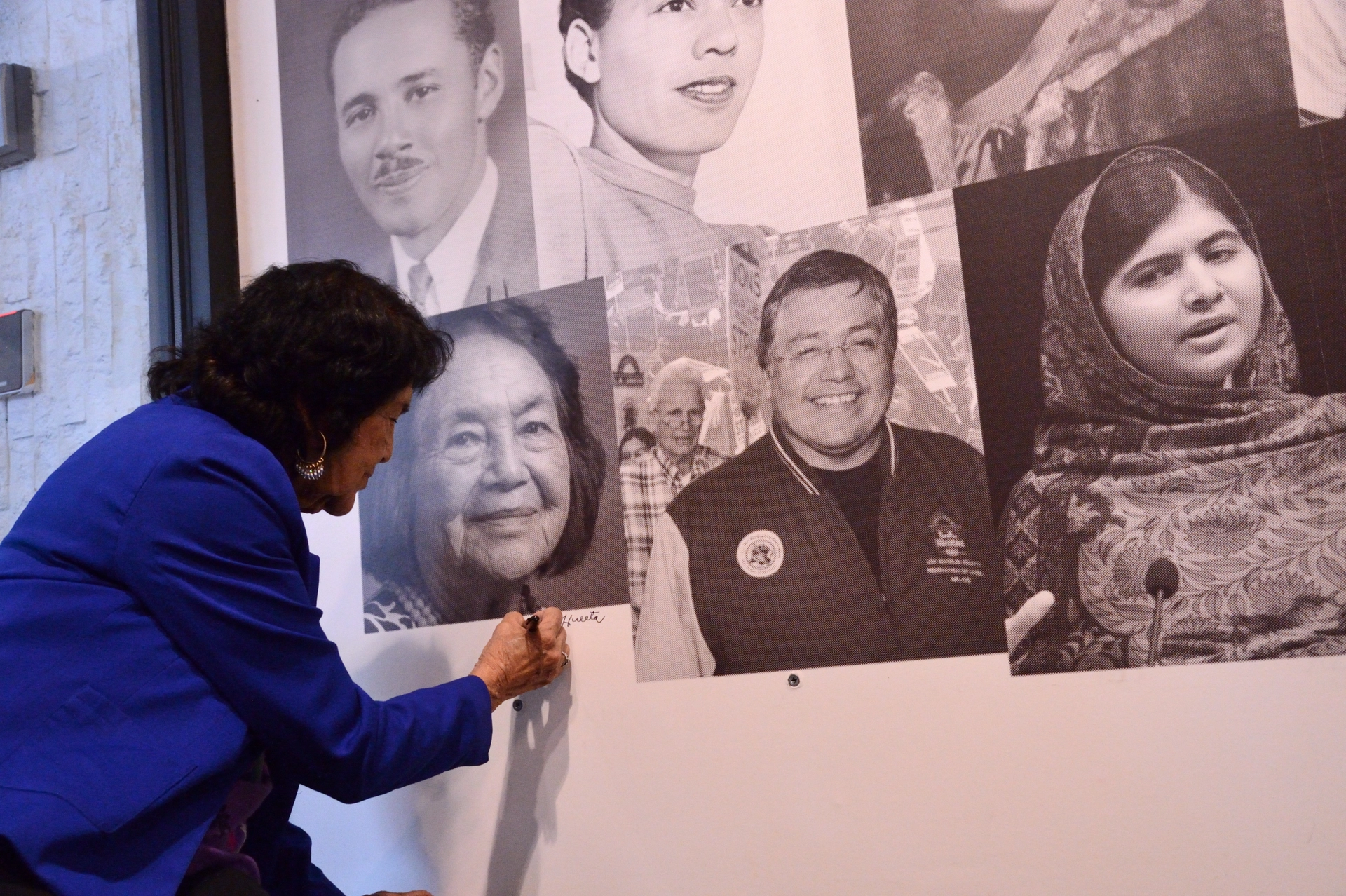 Dolores Huerta signing Heroes Wall mural