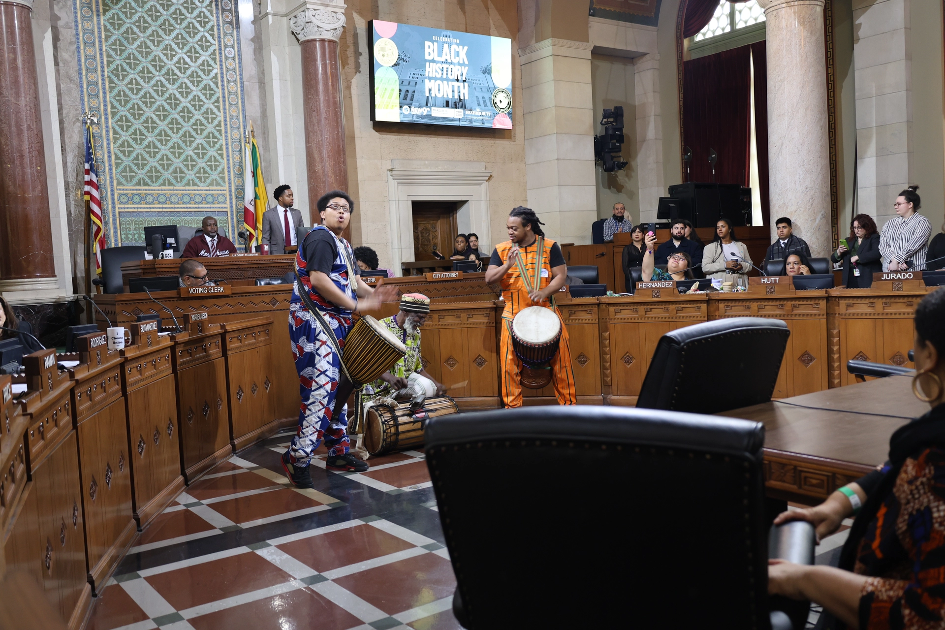 Drummers perform for Black History Month at a City Council meeting.