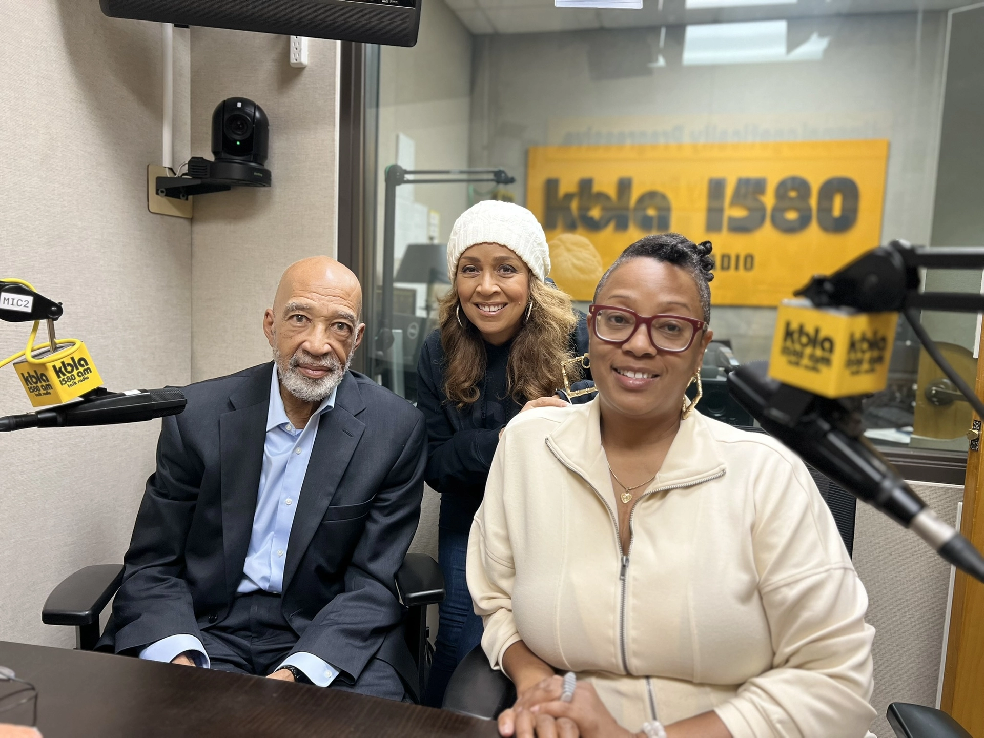 Three people pose in the KBLA studio.
