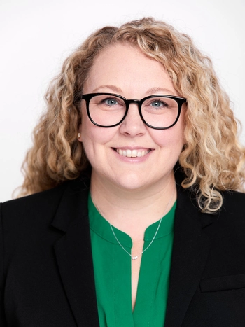 Kim Kasreliovich Headshot Photo wear green blouse and with black blazer